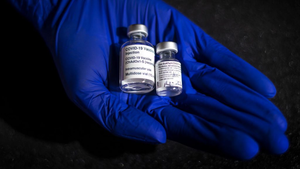 A staff member holds the first ever vials to be administered of the Oxford Astrazeneca (left) and Pfizer-BioNTech vaccines which will form part of a new COVID-19 exhibition at the Science Museum in London when it reopens after lockdown. Picture date: Thursday March 11, 2021. (Photo by Victoria Jones/PA Images via Getty Images)